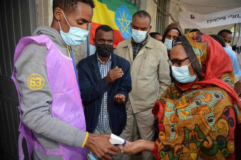 An Ethiopian woman has her hands sanitised as she enters to cast her ballot in the presidential elections. EPA