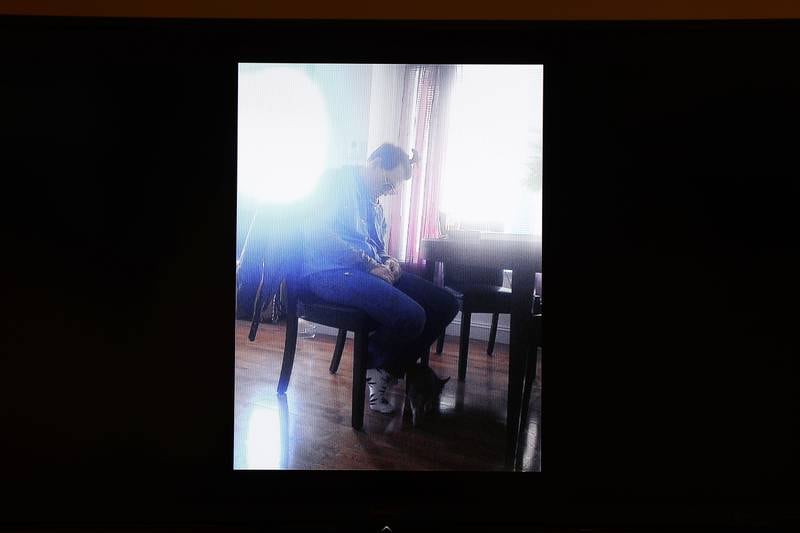 A photo showing Depp falling asleep while sitting up appears on a monitor. EPA