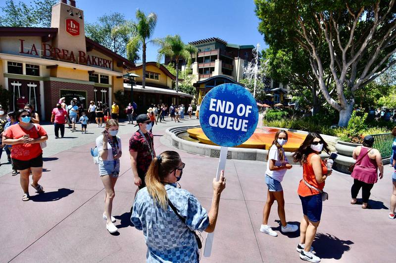A Disney employee runs a line to get in to the virtual queue￼ for World of Disney on the reopening day of the Downtown Disney District on its reopening day in Anaheim, Calif.  AP