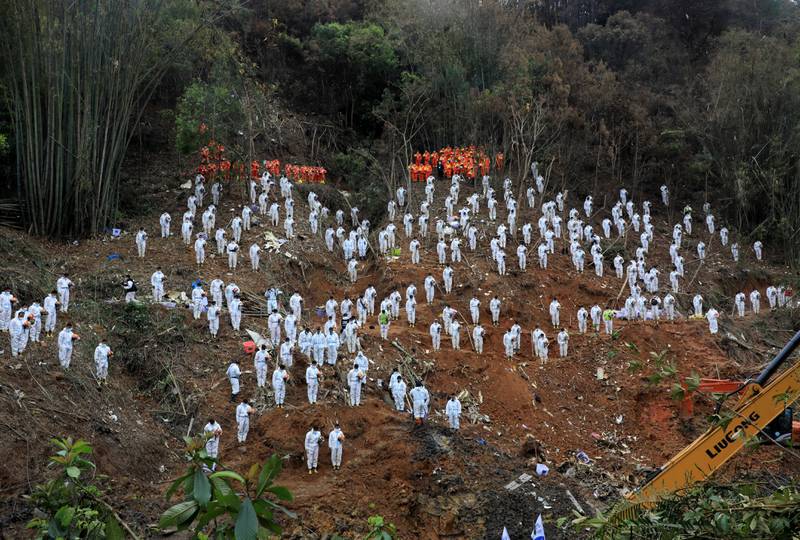 Rescue workers stand in a silent tribute at the site to mourn the victims of Boeing flight MU5735 that crashed in Guangxi Zhuang Autonomous Region, China. Reuters