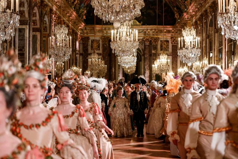 Guests wearing baroque style costumes take part in a ball in the Hall of Mirrors at the Chateau de Versailles Palace as part of the sixth edition's of the Fetes Galantes fancy dress evening which theme is the Royal Wedding of Marie Antoinette and Louis XVI, in Versailles on May 23, 2022.  - The annual fancy dress ball aims to re-create the baroque splendour of the Sun King's dazzling court feasts held to show off the wealth and power of France's longest-reigning monarch.  For tickets costing more than five hundred euros, guests can wander through the private apartments of the chateau, which is a World Heritage site and one of France's biggest tourist attractions.  (Photo by Ludovic MARIN  /  AFP)