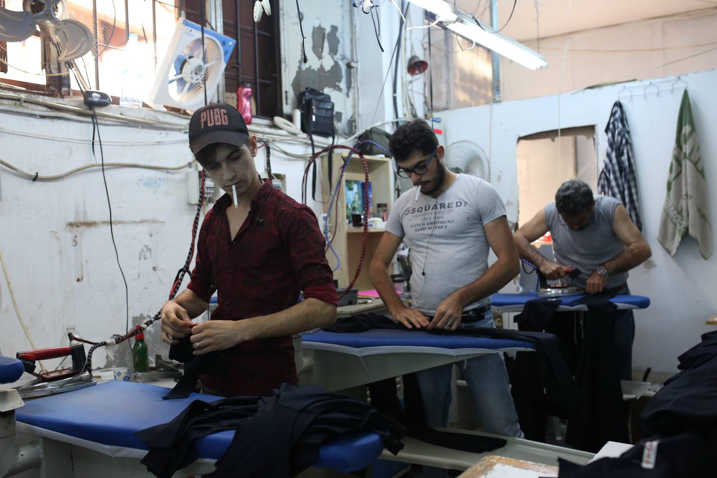 Syrian refugees working as day labourers at a textile workshop in Istanbul in 2019. They are finding jobs harder to find amid rising anti-refugee sentiment and an economic crisis in Turkey. Reuters