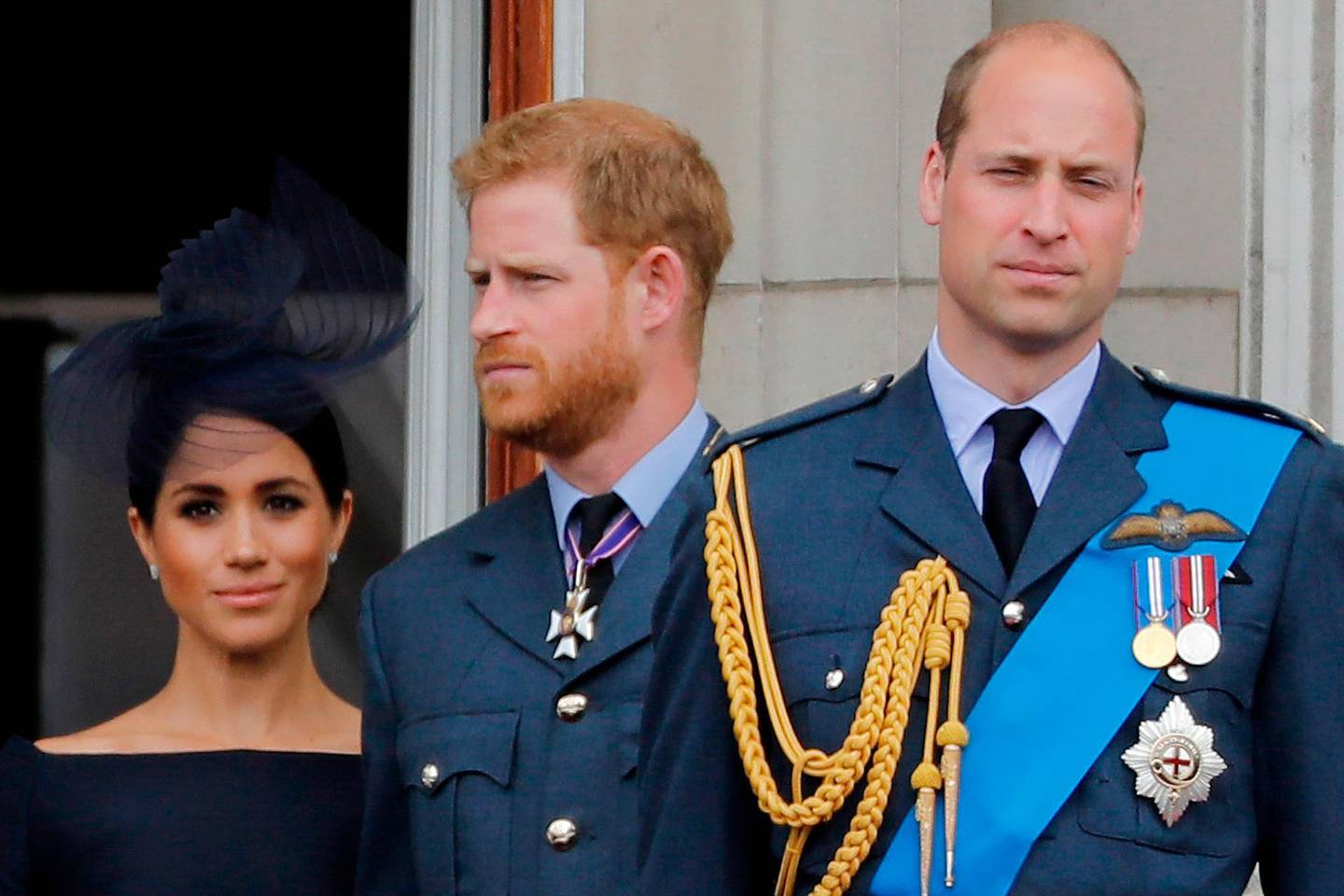 (FILES) In this file photo taken on July 10, 2018 (L-R) Britain's Meghan, Duchess of Sussex, Britain's Prince Harry, Duke of Sussex, and Britain's Prince William, Duke of Cambridge, stand on the balcony of Buckingham Palace to watch a military fly-past to mark the centenary of the Royal Air Force (RAF). Britain's Prince Harry and his wife Meghan will step back as senior members of the royal family and spend more time in North America, the couple said in a shock announcement on January 8, 2020. The surprise news follows a turbulent year for the monarchy, with signs that the couple have increasingly struggled with the pressures of royal life and family rifts. "We intend to step back as 'senior' members of the royal family and work to become financially independent, while continuing to fully support Her Majesty The Queen," they said in a statement released by Buckingham Palace. / AFP / Tolga AKMEN
