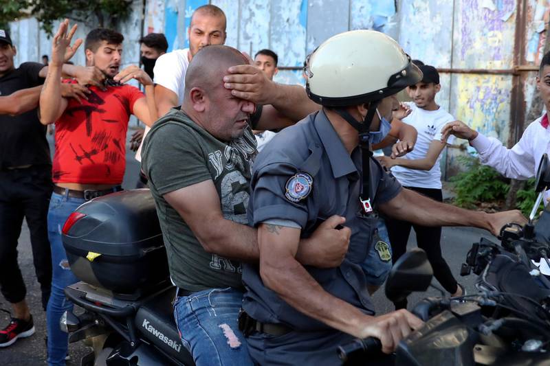 The officer flees the scene on a traffic policeman's motorcycle. AP
