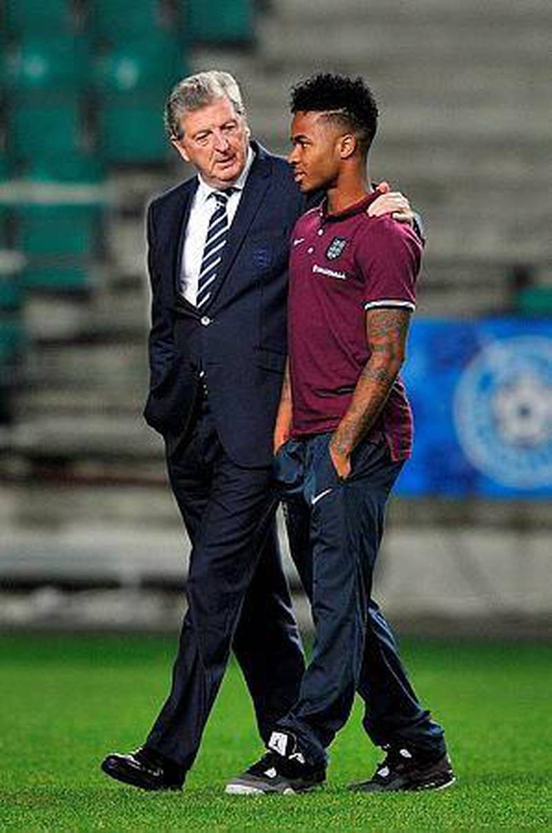 England manager Roy Hodgson, left, talks to midfielder Raheem Sterling at the A.Le Coq Arena in Tallinn, Estonia on October 11, 2014, ahead of the Euro 2016 qualifying group E football match against Estonia in Tallinn on October 12, 2014. AFP PHOTO / GLYN KIRK