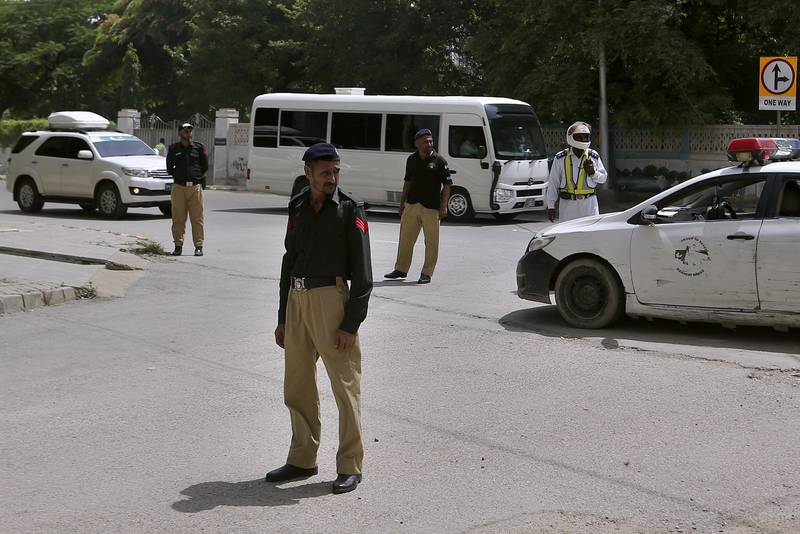 Police officers stand guard while the England cricket team arrive at their hotel in Karachi. AP Photo
