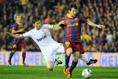 Real Madrid's midfielder Xabi Alonso (L) vies for the ball with Barcelona's Argentinian forward Lionel Messi (R)  during the Spanish Cup final match Real Madrid against Barcelona at the Mestalla stadium in Valencia on April 20, 2011.AFP PHOTO/ JOSE JORDAN (Photo by JOSE JORDAN / AFP)