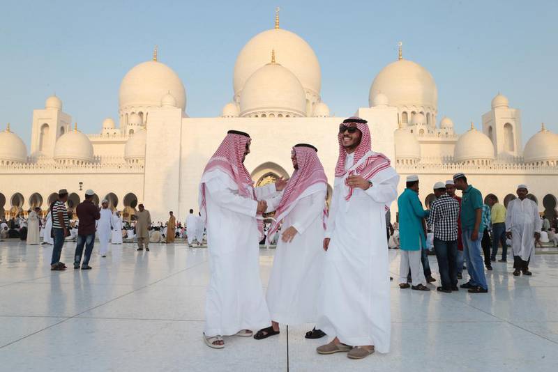 Saudi Arabian men greet each other after Eid Al Fitr prayers at Sheikh Zayed Grand Mosque in Abu Dhabi. Christopher Pike / The National