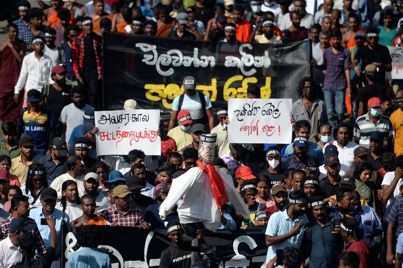 Demonstrators carry an effigy of Mr Wickremesinghe. AFP