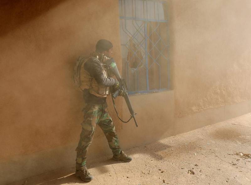 An Iraqi soldier searches a house during clashes with ISIL fighters.