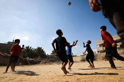 Palestinians play football in a neighbourhood in Gaza amid soaring temperatures and power cuts. AFP