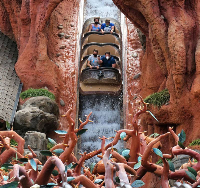 Guests wear masks as required to attend the official reopening day of the Magic Kingdom at Walt Disney World while taking the big plunge on Splash Mountain. AP