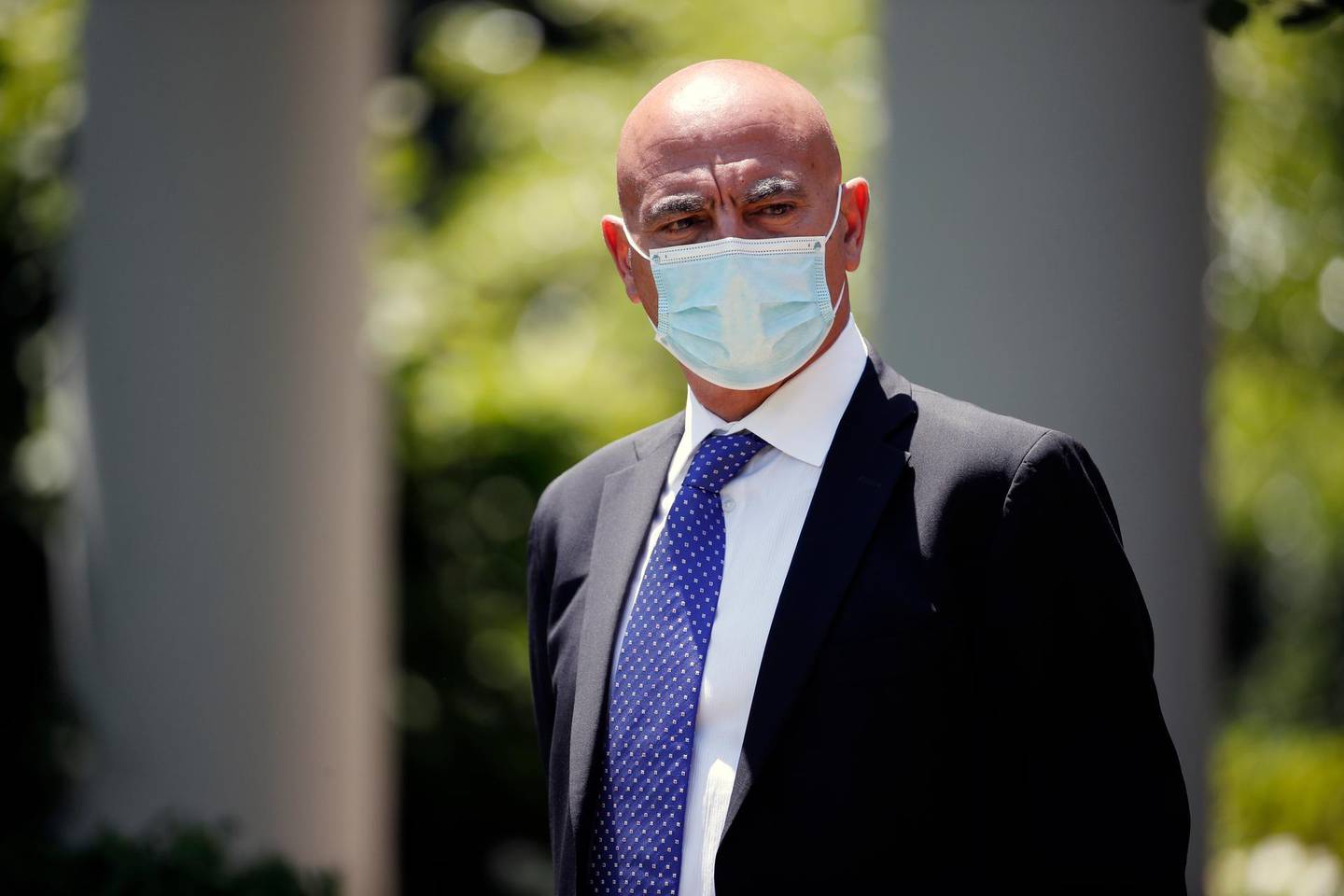 Moncef Slaoui, a former GlaxoSmithKline executive, listens as President Donald Trump speaks about the coronavirus in the Rose Garden of the White House, Friday, May 15, 2020, in Washington. (AP Photo/Alex Brandon)