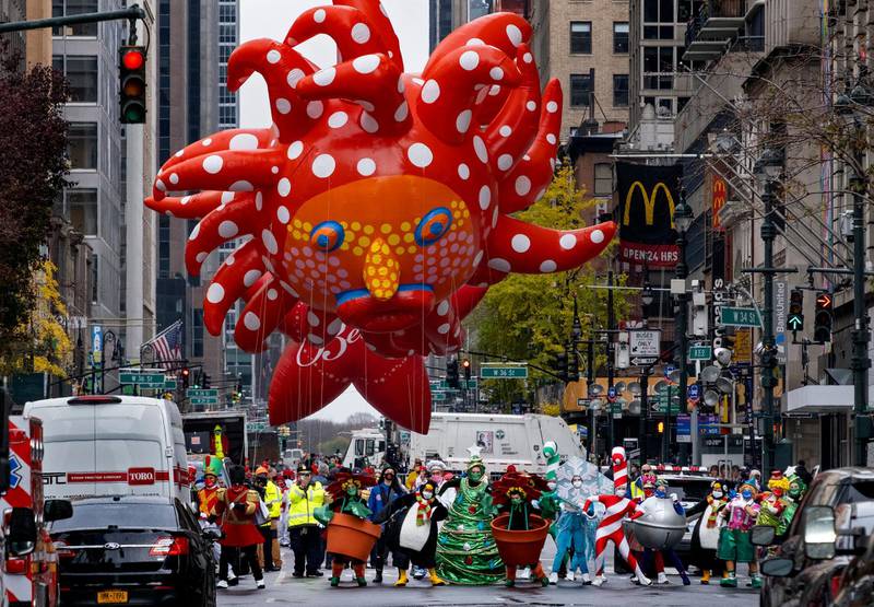 Participants dancing in the modified Macy's Thanksgiving Day Parade are seen from a barricade about two blocks away in New York. Due to the pandemic, crowds of onlookers were not allowed to attend the annual parade. AP Photo