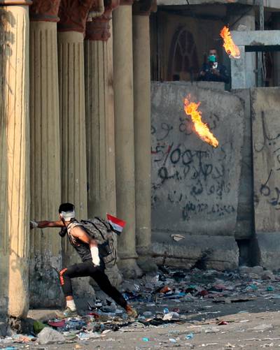 An anti-government protester throws a Molotov cocktail toward riot police during clashes on Rasheed Street, Baghdad. AP Photo