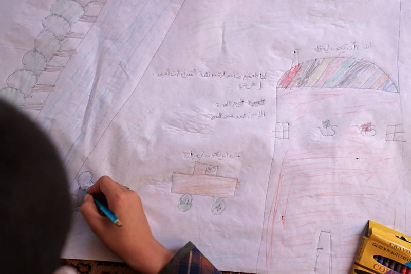 Syrian children creating a banner for the International Day of Peace at a camp for internally displaced people in the village of Killi, in Syria's north-western Idlib province.