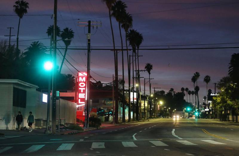 A motel sign is lit along a quiet Sunset Boulevard at dusk amid the coronavirus pandemic on March 31, 2020 in Los Angeles. AFP