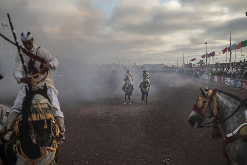 A troupe is engulfed by smoke after firing their rifles during Tabourida, a traditional horse riding show also known as Fantasia, in the coastal town of El Jadida, Morocco.
