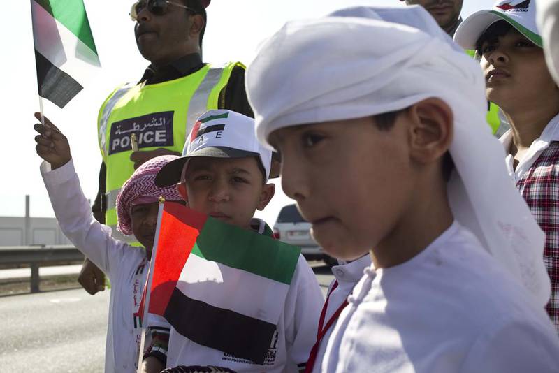 Students from the Al Qurryah School in Fujairah hand out sweets (with the assistance of the police) to morning commuters on the road between Fujairah and Khorfakkan to mark Flag Day Antonie Robertson / The National