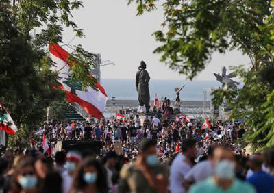 Demonstrators gather by the statue of 'The Lebanese Emigrant' near Beirut port on the first anniversary of the blast that ravaged the port and the city.
