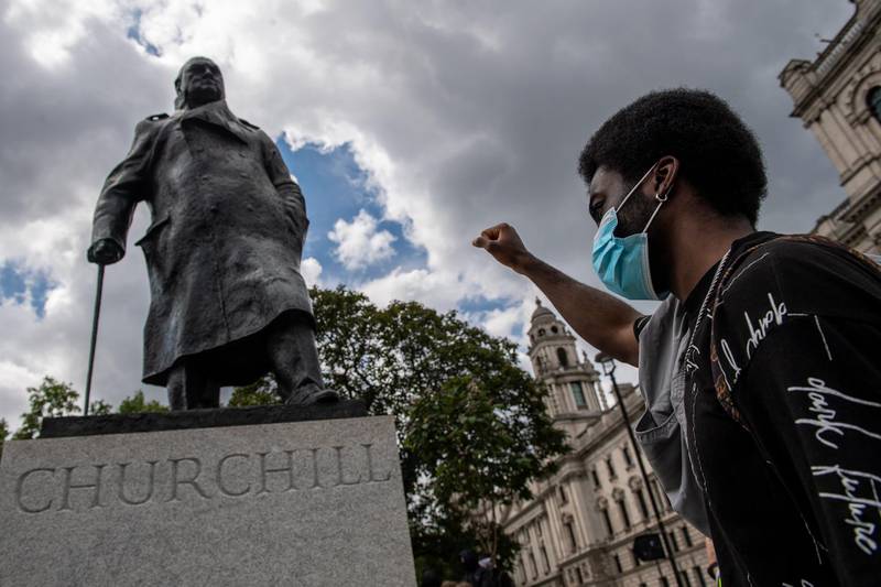 A protester next to a statue of Winston Churchill in Parliament Square during a Black Lives Matter demonstration on June 20, 2020 in London, UK. The movement has triggered the removal of statues with links to racism and the slave trade. Chris J Ratcliffe / Getty