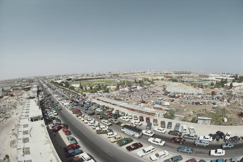 Motor cars are parked outside the ground as spectators gather for the Rothmans Asia Cup cricket match between Pakistan and Sri Lanka on 6 April 1984 at Sharjah Cricket Stadium in Dubai, United Arab Emirates. (Photo by Adrian Murrell/Allsport/Getty Images)