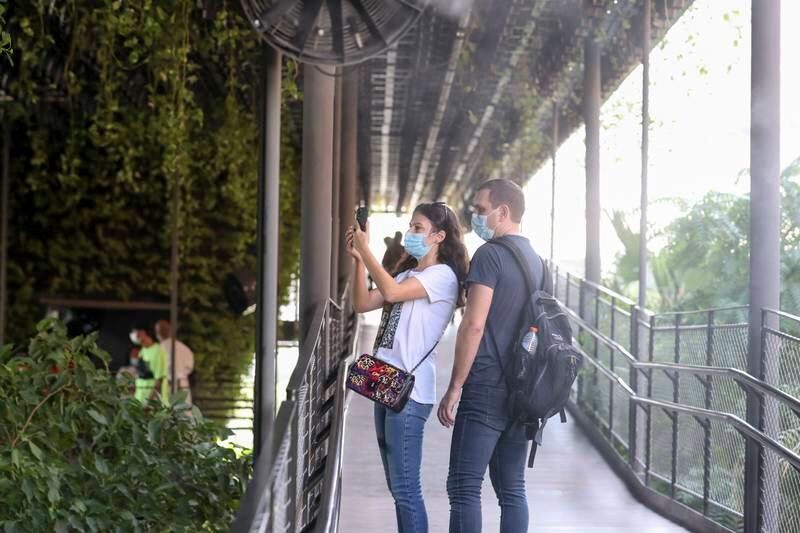 People take photographs of exhibits in the Singapore pavilion. Khushnum Bhandari/ The National