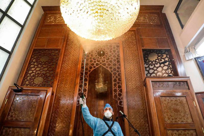 Workers employed by a private cleaning company disinfect a mosque in the flashpoint city of Hebron in the occupied West Bank.   AFP