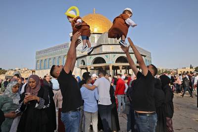 Muslims play with their children as they celebrate Eid Al Fitr in Old Jerusalem. AFP