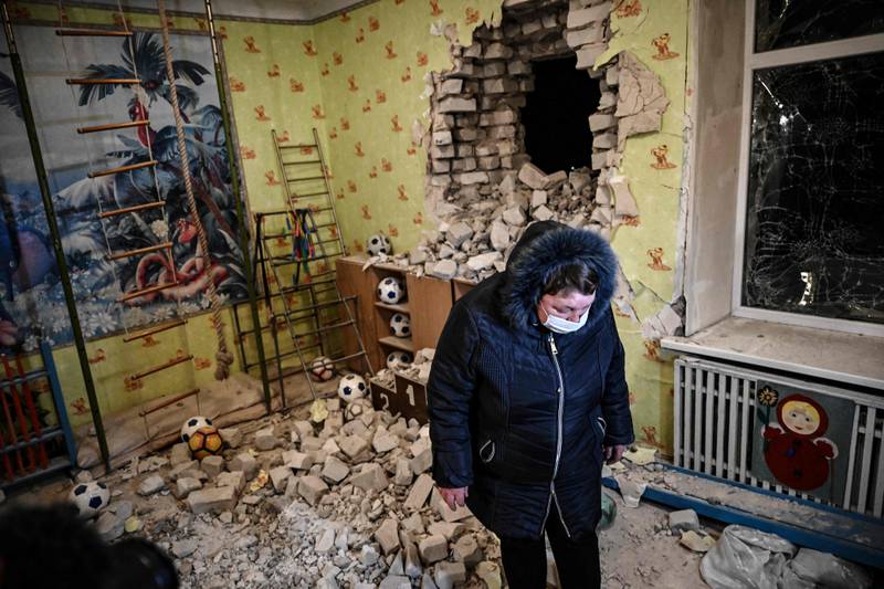 A woman stands among debris after the reported shelling of a nursery in the settlement of Stanytsia Luhanska, Ukraine. AFP