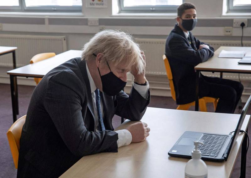 Boris Johnson sits in front of a laptop computer as he takes part in an online lesson during his visit to Sedgehill School. Johnson on Monday set out a four-step plan to ease coronavirus restrictions, expressing hope that life could get back to normal by the end of June. AFP