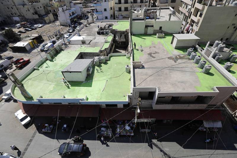 Lebanese painters take part in a project, that aims to draw the word Peace in Arabic across 85 rooftops, in Tripoli's Syria street which separetes the Sunni neighbourhood of Bab al-Tabbaneh from the Alawite neighbourhood of Jabal Mohsen, in Tripoli on September 28, 2017.
The project has been three years in the making, with the artists, 34-year-old twins Mohamed and Omar Kabbani, researching and rejecting multiple locations in their native Lebanon before settling on Tripoli. / AFP PHOTO / Joseph EID