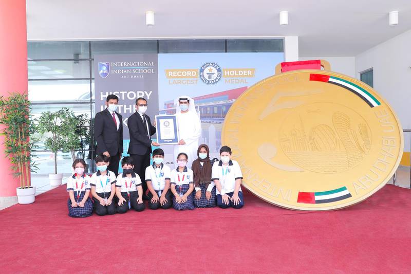 Staff and pupils at International Indian School Abu Dhabi with their record-breaking medal. International Indian School Abu Dhabi