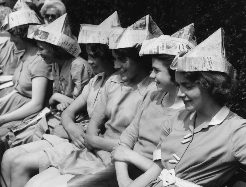 Schoolgirls wear newspaper hats to protect them from the sun while they watch the Wimbledon tennis championships during a heatwave in 1953.