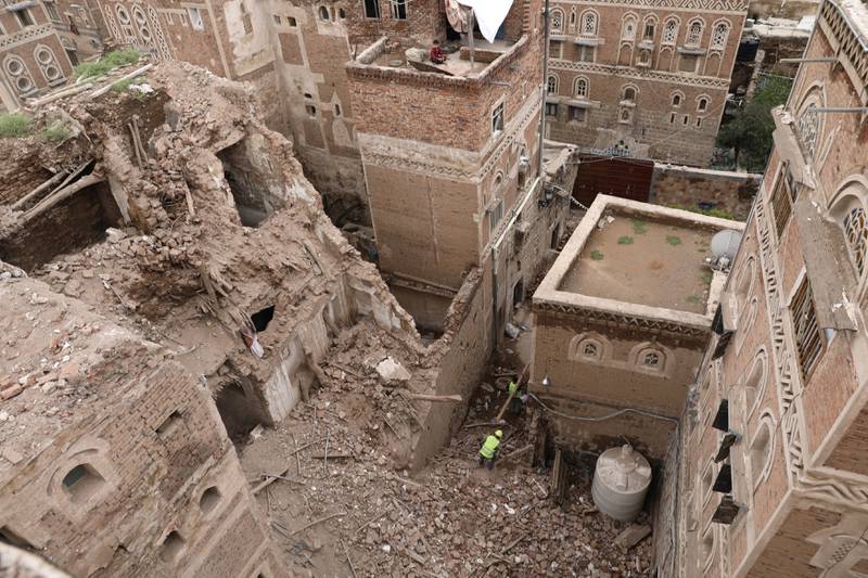 Workers demolish a building damaged by rain in the UNESCO World Heritage site of the old city of Sanaa, Yemen.