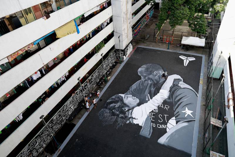 A man polishes the mural in memory of Kobe Bryant and his daughter Gianna, painted hours after they died in a helicopter crash, on the basketball court of a housing tenement in Taguig City, Metro Manila, Philippines, January 28, 2020. REUTERS/Eloisa Lopez