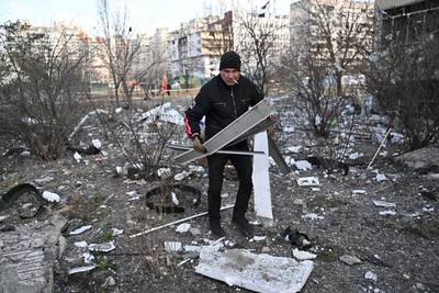 A man outside a damaged housing block after it was hit by debris from a downed rocket in Kyiv. AFP