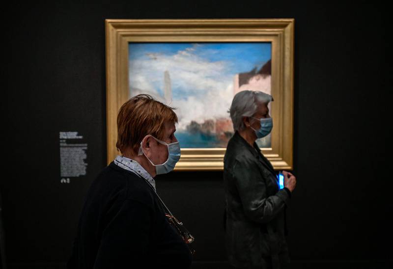 Two women wearing the face masks look at a piece as part of the exhibition of British painter Joseph Mallord William Turner  'Turner - Paintings and watercolours from the Tate' at the Jacquemart-Andre Museum on the first day of the reopening in Paris.  AFP