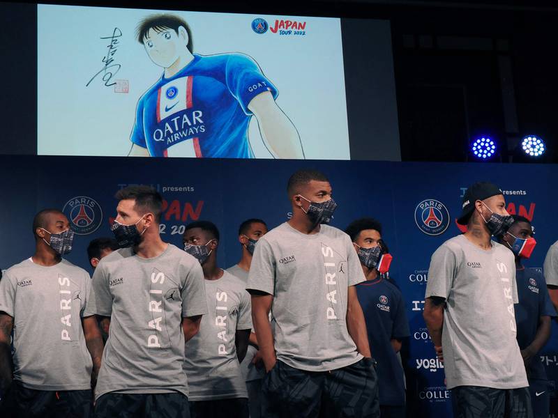 Paris Saint-Germain players Lionel Messi, Kylian Mbappe, Neymar and others stand as an illustration (top) by Yoichi Takahashi, Japanese manga artist, is seen on-screen during a reception party at a Tokyo hotel. AFP