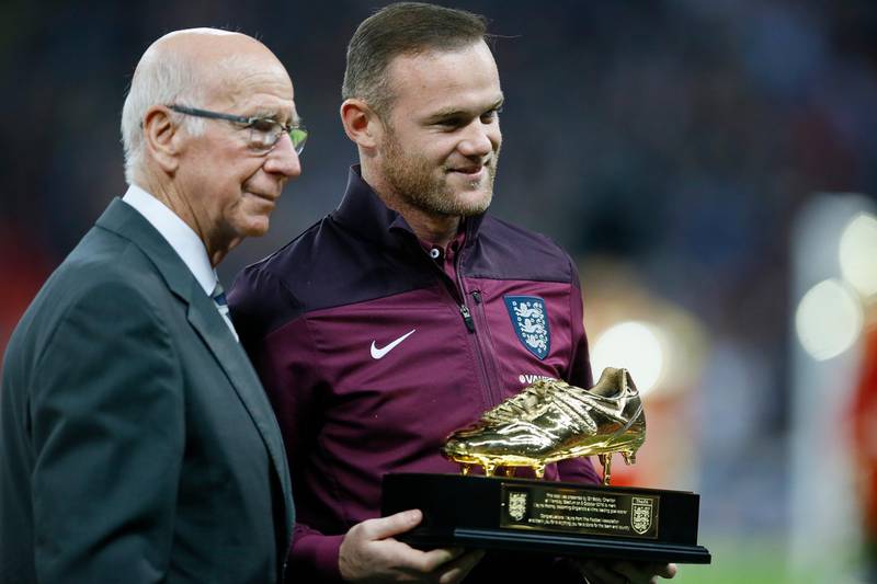 Former Manchester United and England player Bobby Charlton, left, presents Wayne Rooney with a golden boot trophy after Rooney broke Charlton's goal-scoring record, ahead of the Euro 2016 qualifying match between England and Estonia at Wembley in London on October 9, 2015. The former Manchester United captain ended his illustrious playing career to take up a job as full-time manager of Championship club Derby County with a contract up until 2023. AP