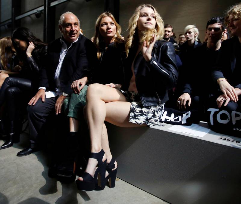 Philip Green, model Kate Moss and her sister Lottie Moss sit in the front row before a Topshop catwalk show during London Fashion Week in 2014. Reuters