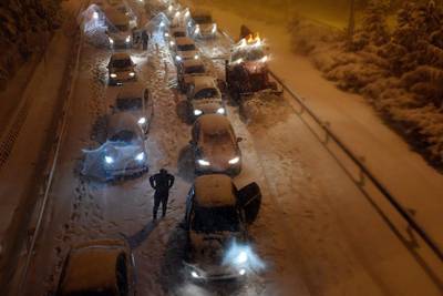 A snowplow removes snow as vehicles remain stuck in the M30 ringroad in Madrid due to a heavy snow storm. AFP