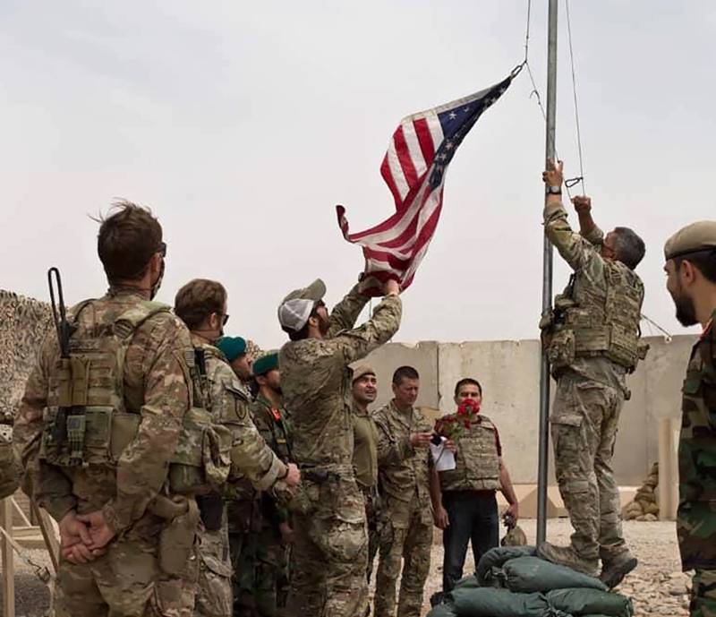 A US flag is lowered as American and Afghan soldiers attend a handover ceremony in Helmand province in May. AP Photo