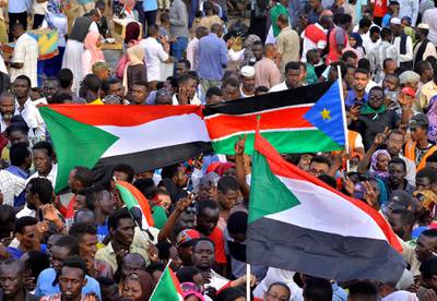 Sudanese demonstrators display their national flag and the national flag of South Sudan, as they attend a sit-in protest outside the Defence Ministry in Khartoum. Reuters