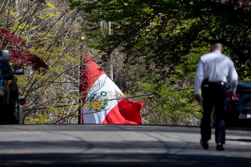 The national flag of Peru is seen at the Peruvian Embassy as a police officer walks down the street. EPA