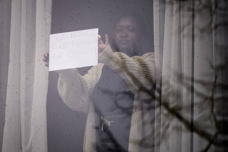 A red list traveller holds up a sign from her quarantine hotel at the Radisson Blu near Heathrow Airport. Getty Images