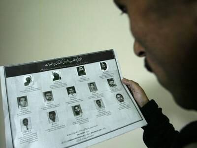 A Pakistani man looks at an advertisement published by the US Embassy in Islamabad in January 2005, containing the names and pictures of the most-wanted Al Qaeda and Taliban leaders, including bin Laden, Al Zawahiri and Mullah Omar. EPA