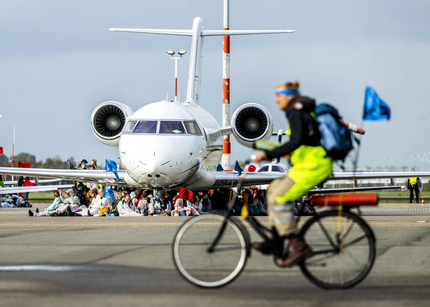 Extinction Rebellion, Greenpeace and other organisations' members cycle past and sit in front of aircraft during their protest. AFP