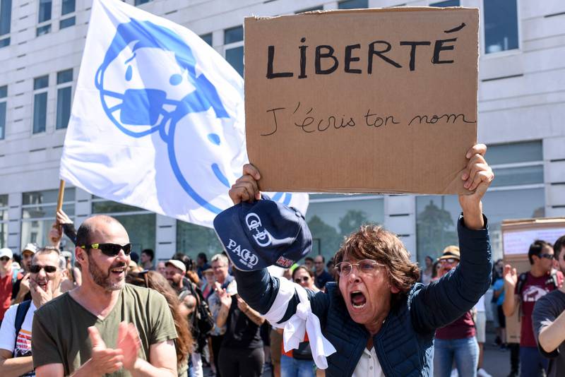 A woman brandishes a placard reading 'Freedom, I write your name' during a demonstration against new coronavirus safety measures called for by the French government in Nantes, western France.