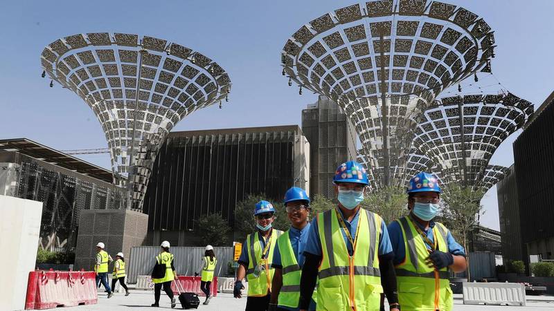 Technicians walk at the under construction site of the Expo 2020 in Dubai.